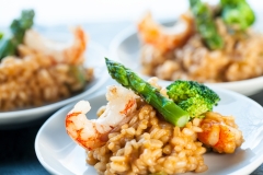 Portion of risotto rice with shrimps and asparagus.